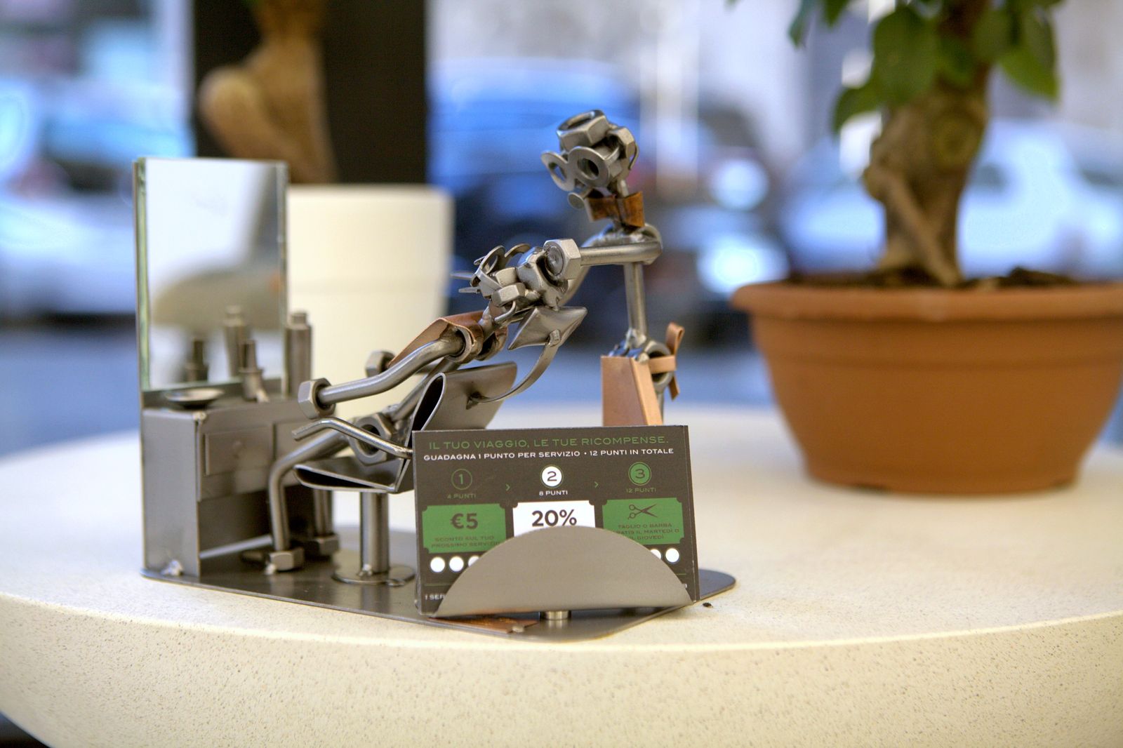 Scultura in metallo e fidelity card sul bancone